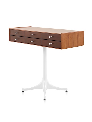 Angled view of a horizontal six-drawer Nelson Miniature Chest with a medium finish and white pedestal base. 