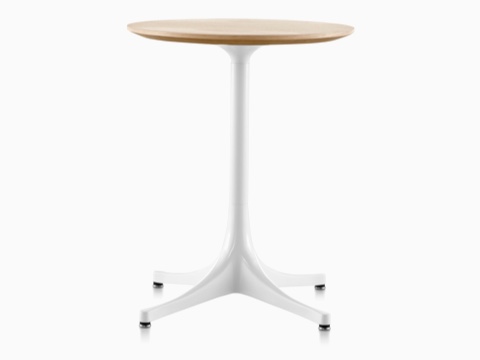 A round Nelson Pedestal Table with a light woodgrain top and white base. 