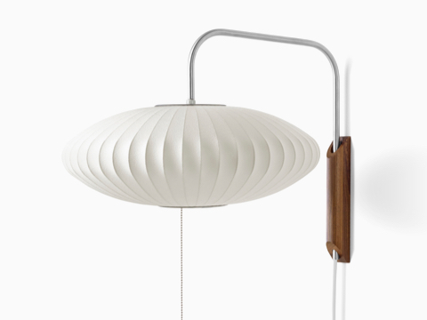 Um candelabro Nelson Saucer com braço giratório e suporte de parede em nogueira. Um candelabro Nelson Saucer com braço giratório e suporte de parede em nogueira.