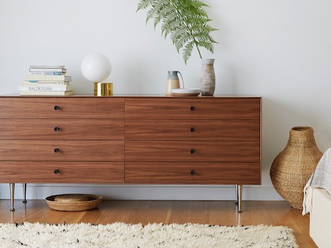 A Nelson Thin Edge double dresser with eight drawers, black knobs, and a medium finish in a residential setting.
