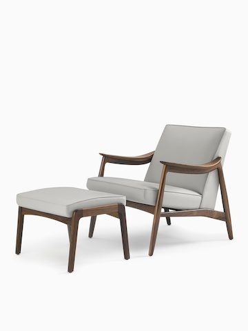 An Aspen Lounge Chair and Ottoman in a gray textile with walnut base and arms.