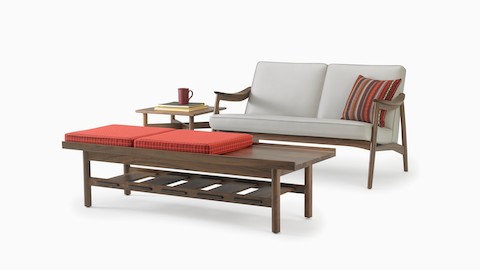 An Aspen lounge settee in a gray textile with walnut base and arms with Hemlock table in walnut and Tamarack Table and Bench in walnut.
