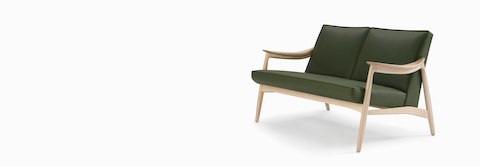 An Aspen lounge settee in green textile with maple base and arms.