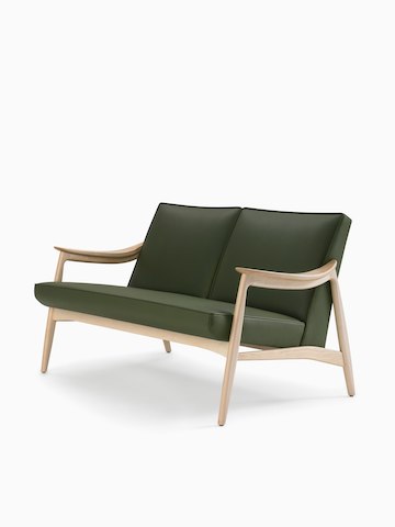 A three-quarter view of an Aspen lounge settee in green textile with maple base and arms.