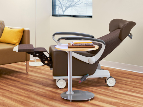 Patient room with a Nemschoff Ava Recliner in a brown upholstery with a Nemschoff Palisade Flop Sofa with a Steps Lounge System Table.