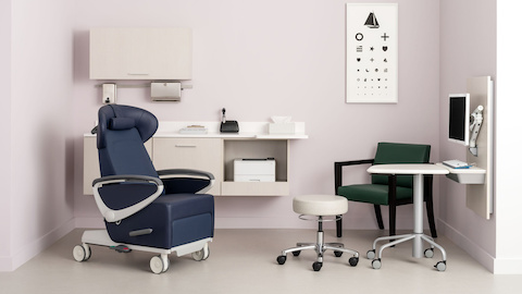 An exam room with Mora System casework in a light wood laminate, a blue Nemschoff Ava patient recliner, an Intent Solution wall unit and mobile, height adjustable table, and a Nemschoff Brava side chair.