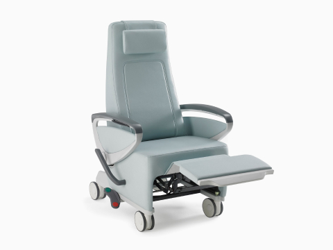 Nemschoff Ava Recliner with arcade back in a light blue upholstery with panel arms and the footrest extended, viewed from an angle. Nemschoff Ava Recliner with arcade back in a light blue upholstery with panel arms and the footrest extended, viewed from an angle.