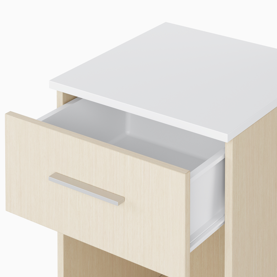 A close-up view of an open drawer with white plastic interior on a Nemschoff Bedside Cabinet.
