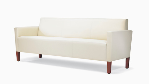 A three-quarter view of a Brava Classic Lounge Sofa with white textile and upholstered arm caps.