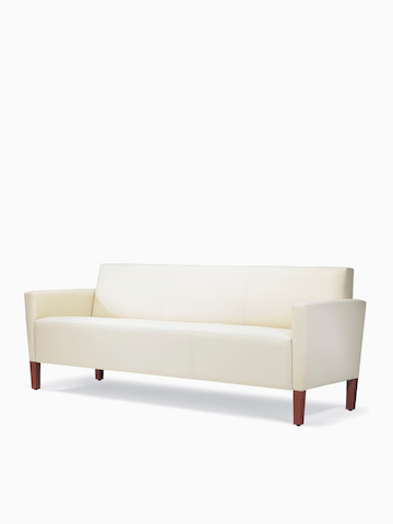A three-quarter view of a Brava Classic Lounge Sofa with white textile and upholstered arm caps.