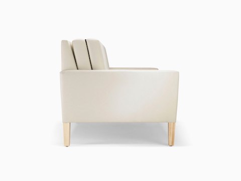 A side view of a Brava Flop Sofa in white textile with maple legs.