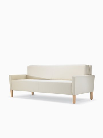 A three-quarter view of a Brava Flop Sofa in white textile with maple legs.