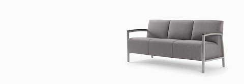 Front three-quarter view of a gray Brava Modern Lounge three-seat chair with wood arm caps.