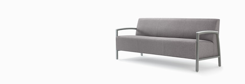 Front three-quarter view of a gray Brava Modern Lounge Seating sofa with solid surface arm caps. Front three-quarter view of a gray Brava Modern Lounge Seating sofa with solid surface arm caps.