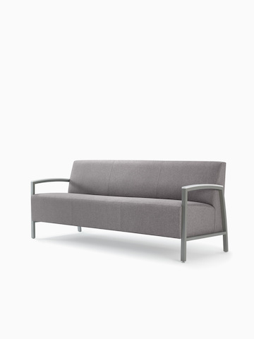 Front three-quarter view of a gray Brava Modern Lounge Seating sofa with solid surface arm caps.