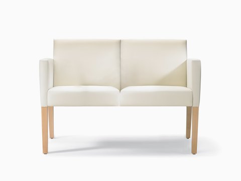 A front view of a Brava 862 Settee in white textile with fully upholstered arms and maple legs.