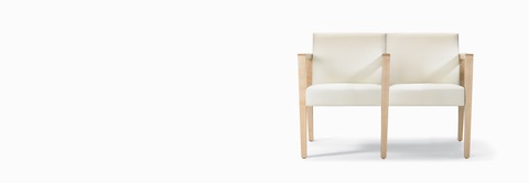 A front view of a Brava 863 two-seat multiple and tandem chair with intervening arms and legs upholstered in white textile with solid maple arms and legs.