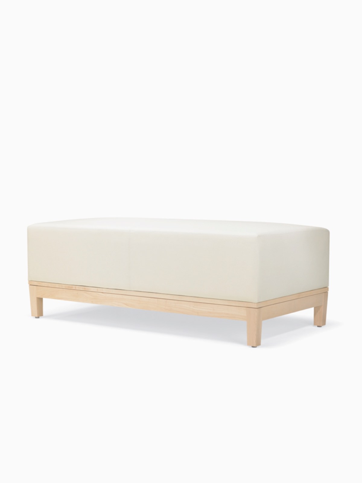 A three-quarter view of a Brava Platform Lounge Bench with maple base and white textile.