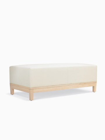 A three-quarter view of a Brava Platform Lounge Bench with maple base and white textile.