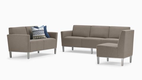 A trio of gray Brava Platform Lounge pieces, consisting of a chair, a two-seat settee including blue pillows, and a three-seat sofa, all on metal bases.