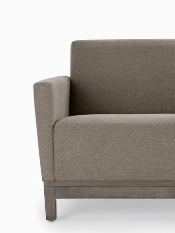Cropped image of a gray Brava Platform Lounge System two-seat sofa with upholstered arms on a wood base.
