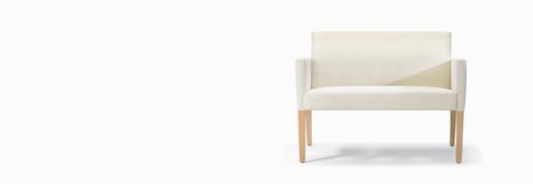 A front view of a Brava 862 plus chair in white textile with upholstered arms and maple legs.