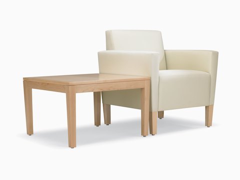 A Brava end table in solid maple and a white Brava Classic Lounge Chair with upholstered arms and maple legs.