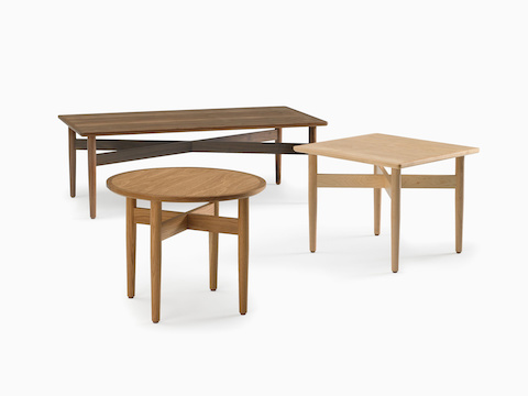 An arrangement of Hemlock tables, including a coffee table in walnut, a square side table in maple, and a round side table in oak.