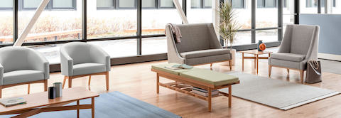 A window filled waiting area featuring a Nemschoff Iris Settee, Nemschoff Sophora Lounge Chairs, and a Nemschoff Tamarack Table and Bench.