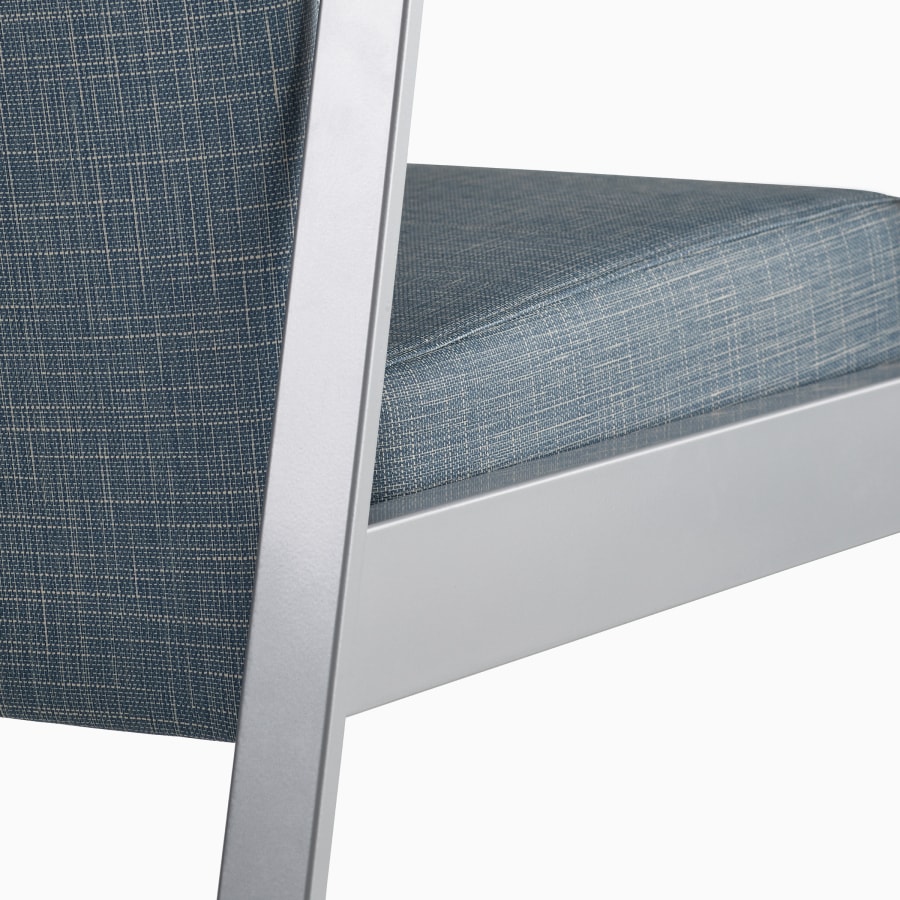 Detail of the back of an Easton chair in blue upholstery and silver frame.