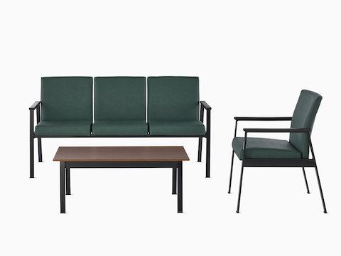 An Easton three-seat Multiple Seating and Easton Side Chair, both in green upholstery and black frames, sit across from an Easton Coffee Table with a medium-matte walnut laminate top and black frame.
