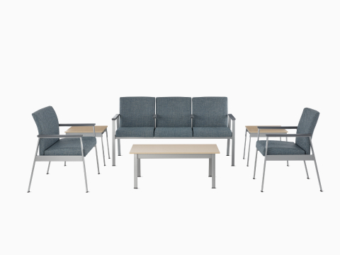 An Easton Plus Chair, Easton three-seat Multiple Seating, and Easton Side Chair, all in blue upholstery, sit next to Easton Side Tables and across from an Easton Coffee Table with clear on ash laminate tops and metallic silver frames. An Easton Plus Chair, Easton three-seat Multiple Seating, and Easton Side Chair, all in blue upholstery, sit next to Easton Side Tables and across from an Easton Coffee Table with clear on ash laminate tops and metallic silver frames.