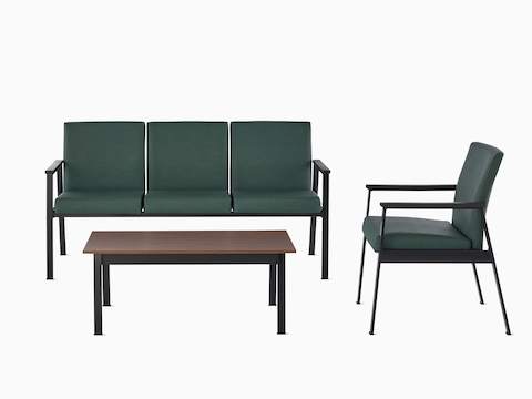 Easton three-seat multiple seating sits perpendicular to an Easton Side Chair both with green upholstery and black frame. An Easton Coffee Table with a medium matte walnut laminate top and black frame lies in front.