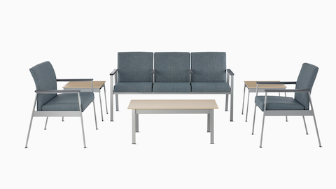 An Easton Plus Chair, Easton three-seat Multiple Seating, and Easton Side Chair, all in blue upholstery, sit next to Easton Side Tables and across from an Easton Coffee Table with clear on ash laminate tops and metallic silver frames. An Easton Plus Chair, Easton three-seat Multiple Seating, and Easton Side Chair, all in blue upholstery, sit next to Easton Side Tables and across from an Easton Coffee Table with clear on ash laminate tops and metallic silver frames.