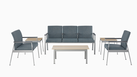 An Easton Plus Chair, Easton three-seat Multiple Seating, and Easton Side Chair, all in blue upholstery, sit next to Easton Side Tables and across from an Easton Coffee Table with clear on ash laminate tops and metallic silver frames. An Easton Plus Chair, Easton three-seat Multiple Seating, and Easton Side Chair, all in blue upholstery, sit next to Easton Side Tables and across from an Easton Coffee Table with clear on ash laminate tops and metallic silver frames.