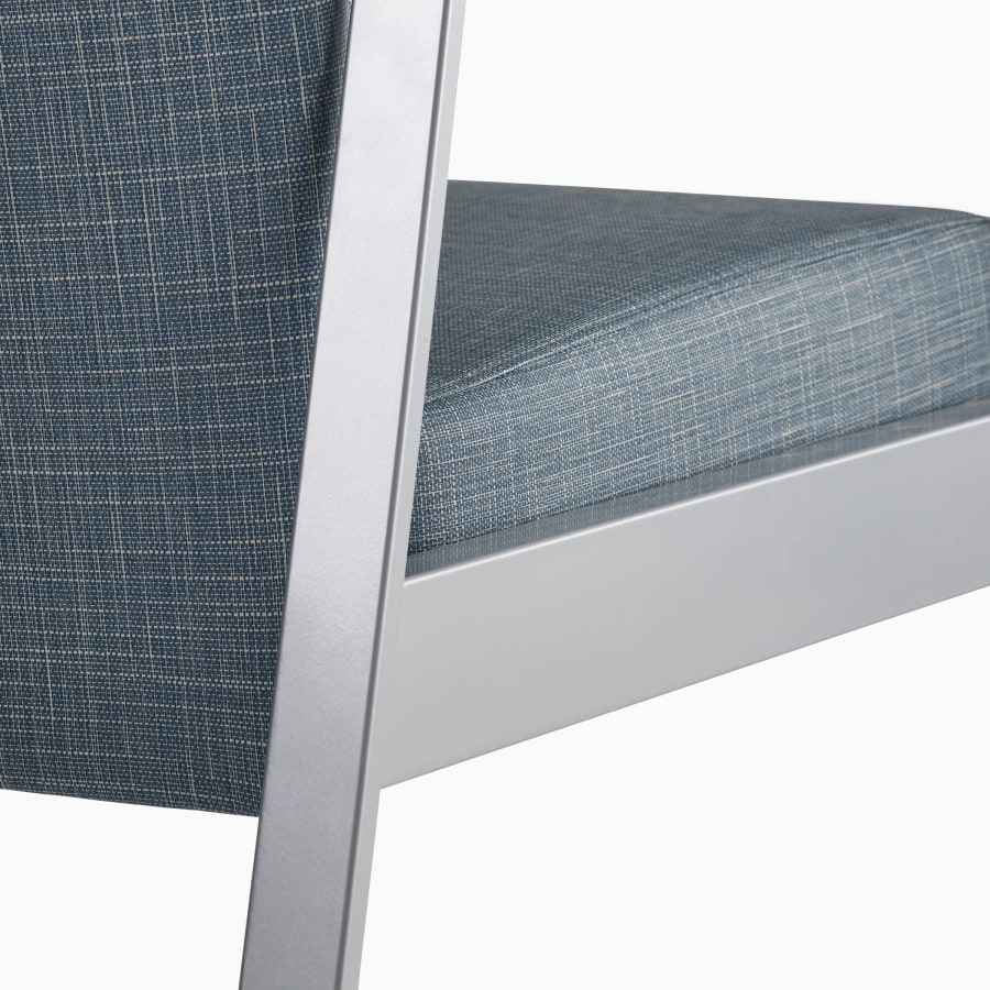 Detail of the back of an Easton chair in blue upholstery and silver frame..