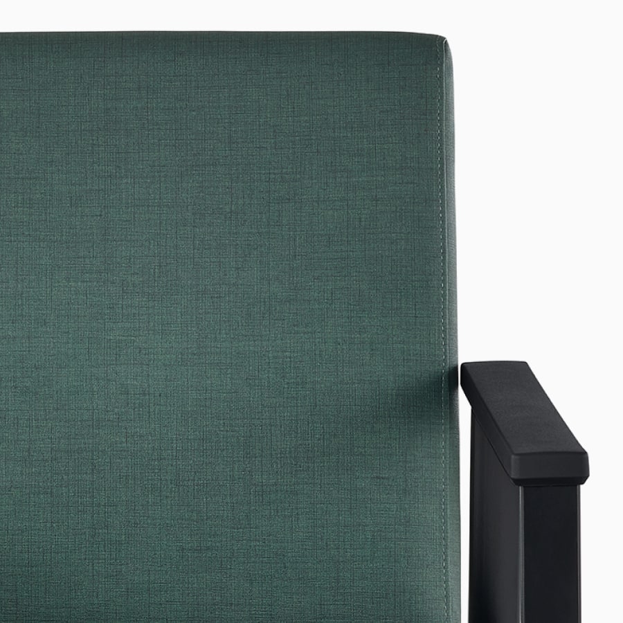 Front-view detail of an Easton chair with green upholstery and black arm caps.