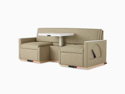 Angled view of Nemschoff Merge 2 Flop Sofa in a beige upholstery with a white center table in the up position and a natural maple base.