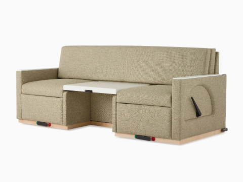 Angled view of a Nemschoff Merge 2 Flop Sofa in a beige upholstery with a white center table and a natural maple base.