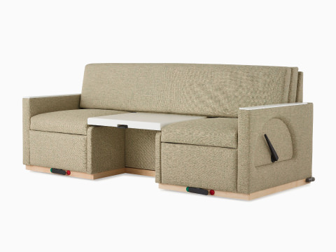 Angled view of a Nemschoff Merge 2 Flop Sofa in a beige upholstery with a white center table and a natural maple base. Angled view of a Nemschoff Merge 2 Flop Sofa in a beige upholstery with a white center table and a natural maple base.