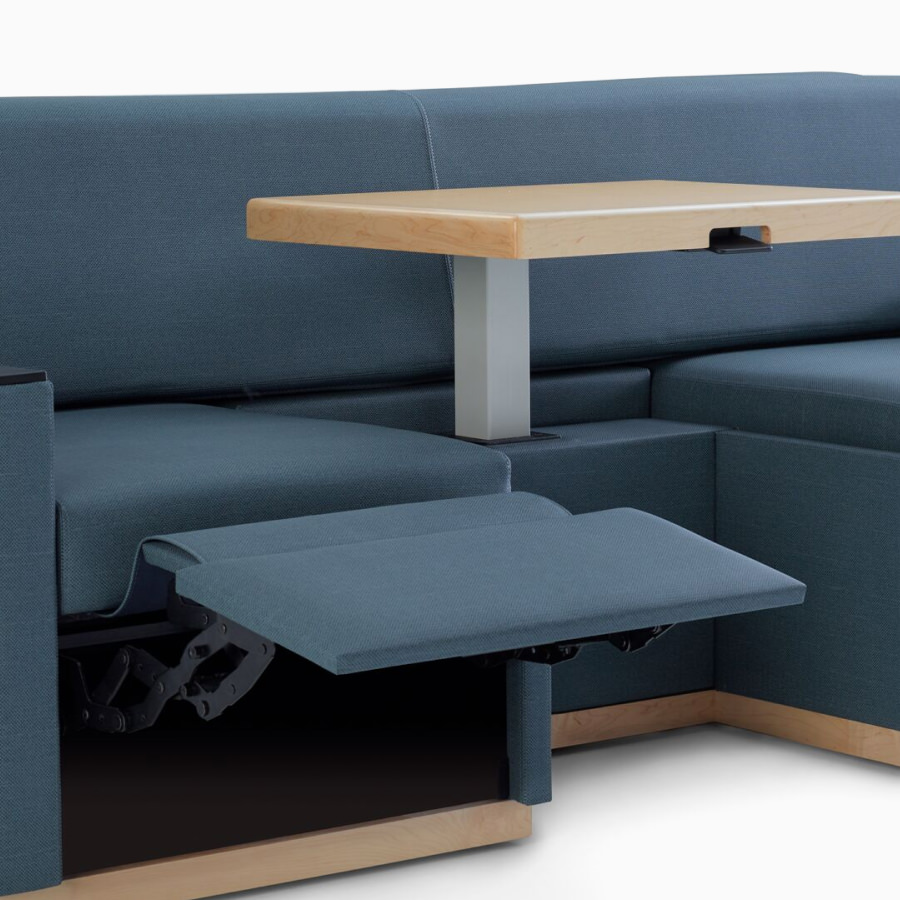Nemschoff Merge 2 Flop Sofa with footrest in dark blue textile with light wood table and black solid surface arm caps.