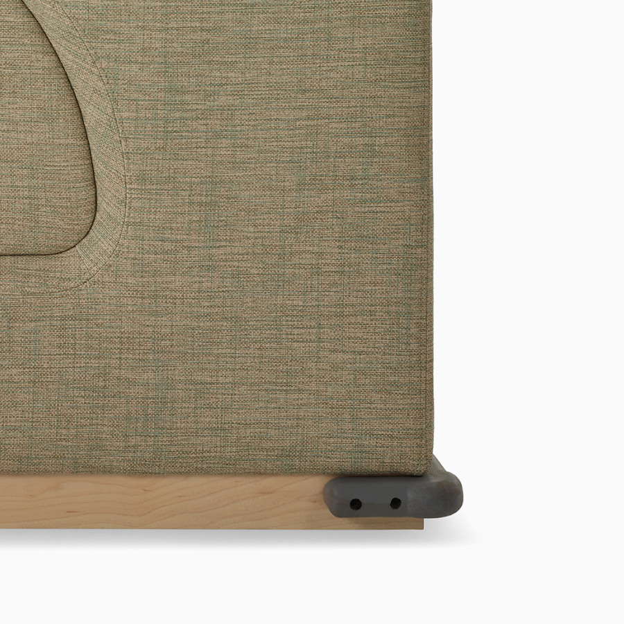 Detail of a wallsaver corner bumper on a Nemschoff Merge 2 Flop Sofa in a beige upholstery with a natural maple base.