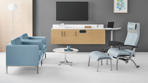 A patient room featuring Nemschoff Riva lounge chairs in blue textile across from a light blue Nemschoff Nala Patient Chair and a Nelson side table. A patient room featuring Nemschoff Riva lounge chairs in blue textile across from a light blue Nemschoff Nala Patient Chair and a Nelson side table.
