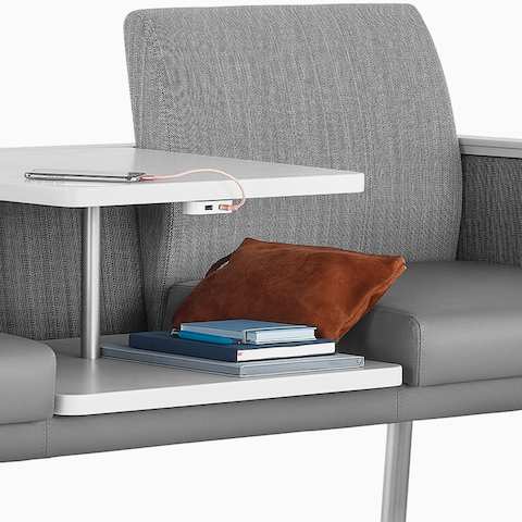 Detail three-quarter front view of Nemschoff Palisade Easy Access in a gray upholstery with a white height-adjustable center table with power outlets.
