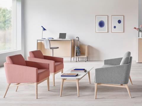 Bright waiting room featuring Palisade Lounge Chairs in pink, a sofa in gray, and  white and light wood Palisade Coffee Table.
