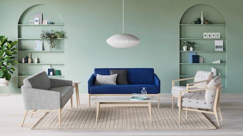 Peaceful lounge seating featuring a bright blue Palisade Sofa and other Palisade lounge seats in gray and neutral patterned fabrics, with a Palisade Coffee Table anchoring the setting.