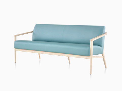 Three-quarter view of a teal Palisade Sofa with wood legs.