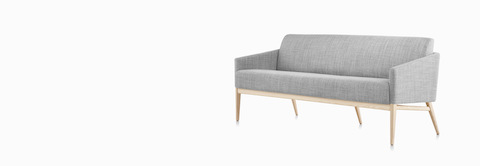 Three-quarter view of Palisade Sofa in gray fabric with wood legs.