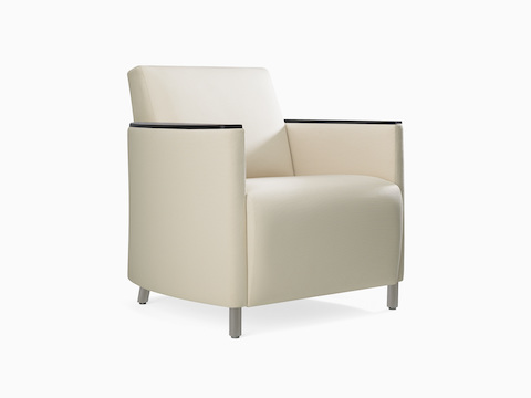 A three-quarter view of a Pamona Armchair in a white upholstery with black urethane arm caps.