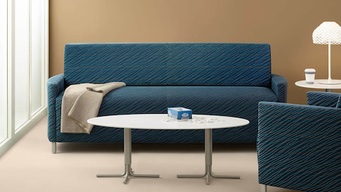 Nemschoff Pamona Flop Sofa in a medium blue patterned upholstery in a grouping of an armchair, coffee table, and side table.